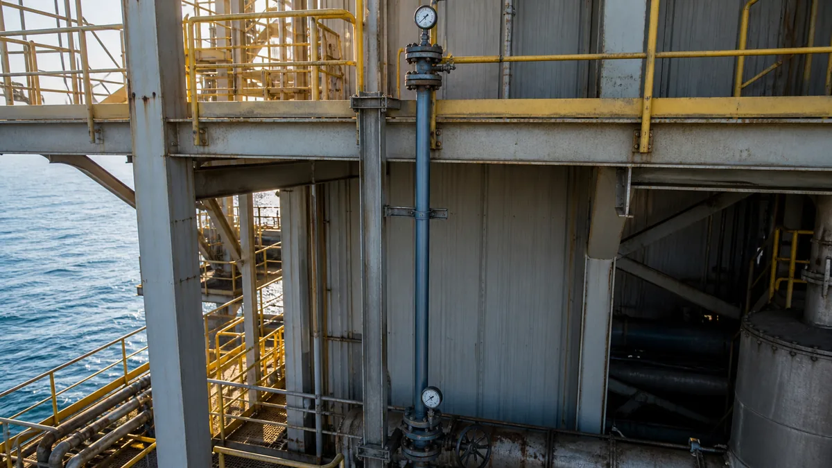 Manômetros instalados em pontos baixo e alto de uma tubulação vertical durante teste hidrostático